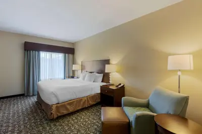 a hotel room with a bed and a chair at Best Western Plus Walkerton Hotel & Conference Centre in Walkerton