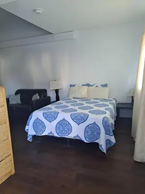 a bedroom with a bed with a blue and white comforter at Campbellford Studio Apt 4 in Campbellford