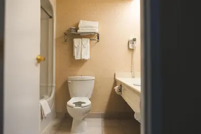 a bathroom with a toilet and a sink with towels at The Casablanca Hotel in Grimsby