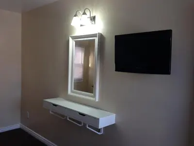a bathroom with a mirror and a television on the wall at Davidson Motel in Paris