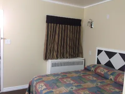 a bedroom with a bed and a window at Davidson Motel in Paris