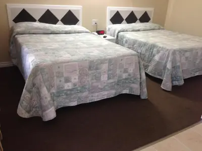 two beds in a hotel room with two beds sidx sidx sidx at Davidson Motel in Paris