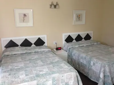 a bedroom with two beds and a night stand with a phone at Davidson Motel in Paris
