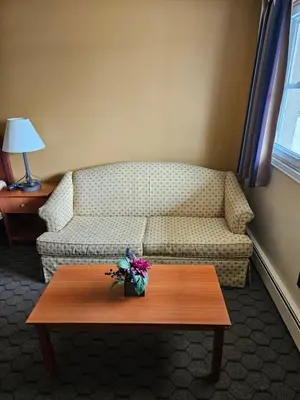 a living room with a couch and a coffee table at Forest Plaza Motel in Mount Forest