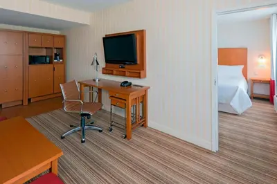 a hotel room with a bed and a desk with a computer at Four Points by Sheraton Cambridge Kitchener, Ontario in Cambridge