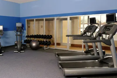 a gym with treadmills and a row of machines at Four Points by Sheraton Cambridge Kitchener, Ontario in Cambridge