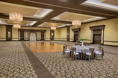 a banquet hall with tables and chairs and chandeliers at Four Points by Sheraton London in London