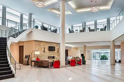 an office lobby with a staircase and a stone fireplace at Four Points by Sheraton London in London