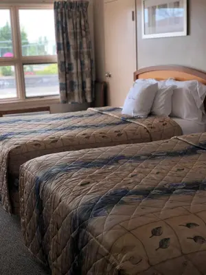 a hotel room with two beds and a window at Good Night Inn in Port Colborne