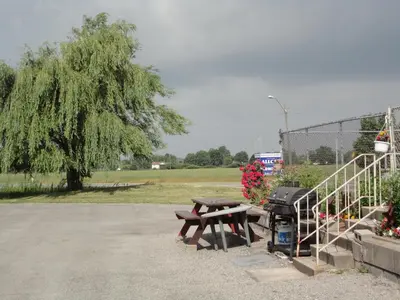 a picnic table and a grill in a park at Good Night Inn in Port Colborne