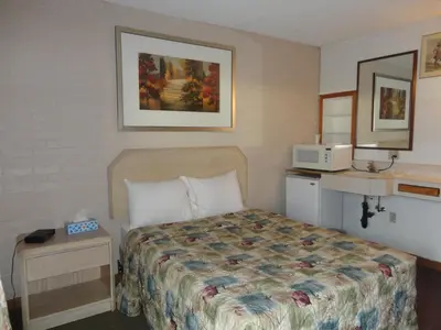 a hotel room with a bed and a microwave at Good Night Inn in Port Colborne