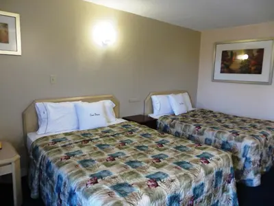 a room with two beds in a hotel room at Good Night Inn in Port Colborne
