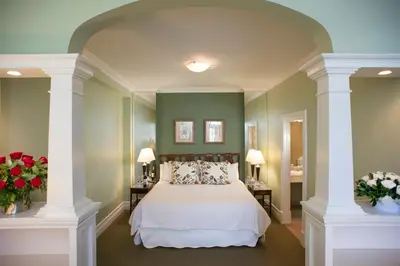 a bedroom with green walls and a bed with flowers at Inn On The Twenty in Jordan