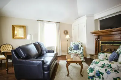 a living room with a leather couch and a chair at Inn On The Twenty in Jordan