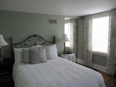 a bedroom with a white bed and two windows at Inn On The Twenty in Jordan