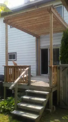a wooden deck with awning and stairs in front of a house at Maison Doucet in Niagara Falls