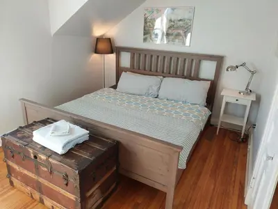a bedroom with a bed with a wooden frame at Doucet Guesthouse in Hamilton