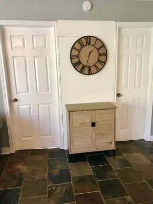 a room with a clock on the wall and two doors at Blue Mountain (1 bedroom) Escape at North Creek Resort in Blue Mountains