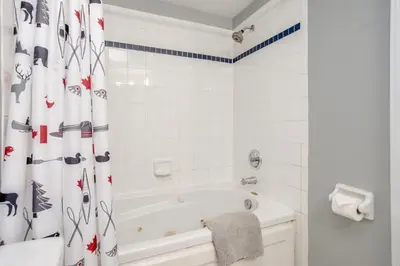 a white bathroom with a tub and a shower curtain at Blue Mountain (1 bedroom) Escape at North Creek Resort in Blue Mountains