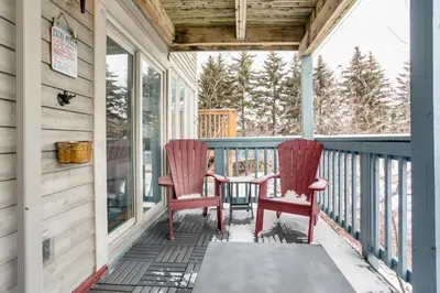 a porch with two red chairs and a table at Blue Mountain (1 bedroom) Escape at North Creek Resort in Blue Mountains