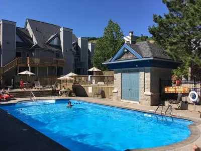 a person swimming in a large blue swimming pool at Blue Mountain (1 bedroom) Escape at North Creek Resort in Blue Mountains