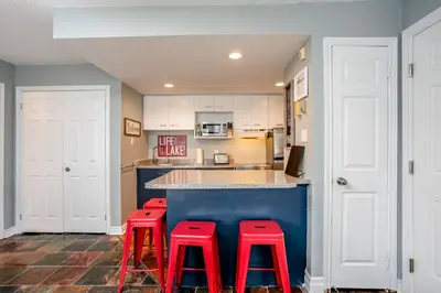 a kitchen with three red stools in front of a counter at Blue Mountain (1 bedroom) Escape at North Creek Resort in Blue Mountains