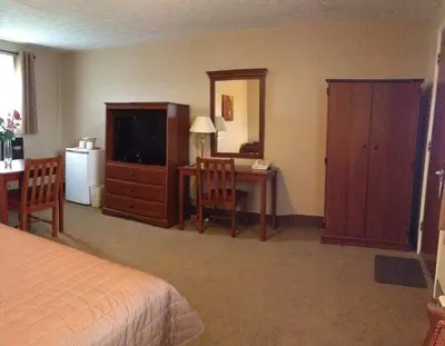 a bedroom with a bed and a desk and a television at Majers Motel in Stratford