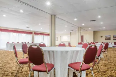 a conference room with a white table and red chairs at Quality Inn in Bracebridge