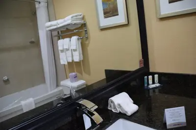 a bathroom with a sink and a mirror and towels at Quality Inn in Bracebridge