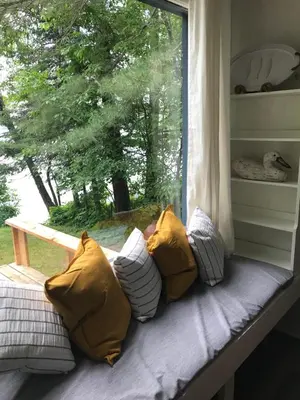 a window seat with pillows and a window with a view at Beachside on Lake Muskoka in Port Carling