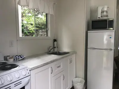 a kitchen with a sink and a white refrigerator at Beachside on Lake Muskoka in Port Carling