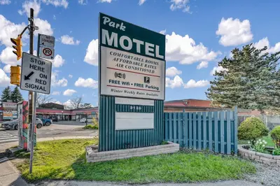 a sign for a motel on the corner of a street at Park Motel in Toronto