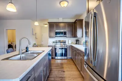 a kitchen with a stainless steel refrigerator and wooden floors at GlobalStay Modern House near Huron Lake Port Elgin in Port Elgin
