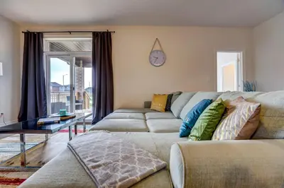 a living room with a couch and a clock on the wall at GlobalStay Modern House near Huron Lake Port Elgin in Port Elgin