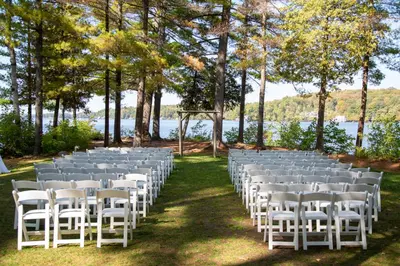 a row of white chairs are lined up for a wedding ceremony at Sherwood Inn in Port Carling