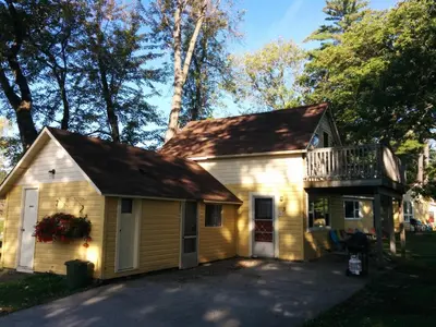 a small yellow house with a balcony on top at Sunrise Resort in Buckhorn