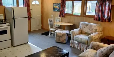 a kitchen with a refrigerator and chairs and a table at Sunrise Resort in Buckhorn