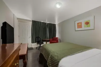 a hotel room with a bed and a desk and a chair at Knights Inn Burlington in Burlington