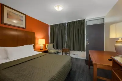 a hotel room with a bed and a desk and a window at Knights Inn Burlington in Burlington