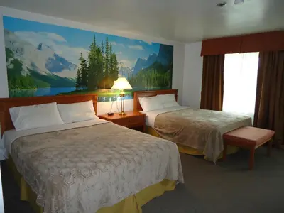 a hotel room with two beds and a painting on the wall at Westmount Motel in Woodstock