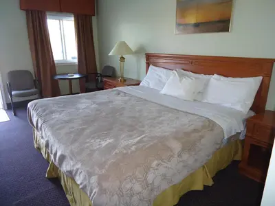 a hotel room with a large bed with white pillows at Westmount Motel in Woodstock