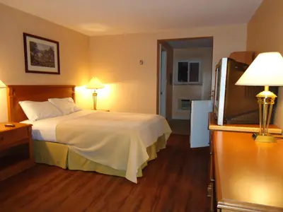 a hotel room with a bed and a flat screen tv at Westmount Motel in Woodstock
