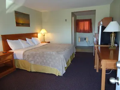 a hotel room with a bed and a flat screen tv at Westmount Motel in Woodstock
