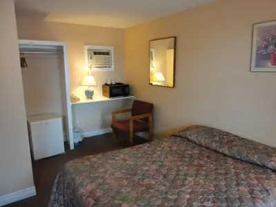 a hotel room with a bed and a desk at Hipwell's Motel in Fonthill