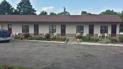 a house with chairs in a parking lot at Hipwell's Motel in Fonthill