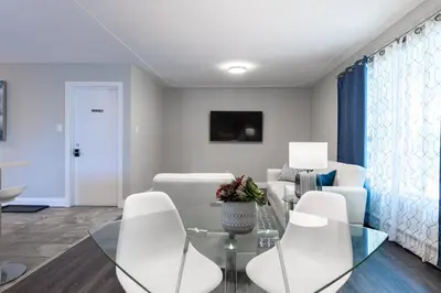 a living room with a glass table and white chairs at ENTIRE 2 BEDROOM APARTMENT UPTOWN WATERLOO - e3 in Waterloo