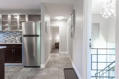 a stainless steel refrigerator in a kitchen with a hallway at ENTIRE 2 BEDROOM APARTMENT UPTOWN WATERLOO - e3 in Waterloo