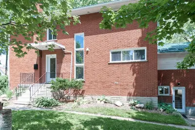 a brick house with a front door and a yard at ENTIRE 2 BEDROOM APARTMENT UPTOWN WATERLOO - e3 in Waterloo