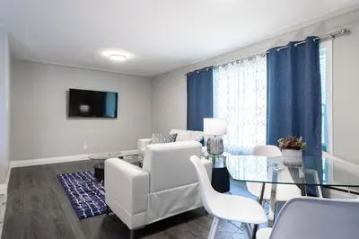 a living room with white furniture and a glass table at ENTIRE 2 BEDROOM APARTMENT UPTOWN WATERLOO - e3 in Waterloo