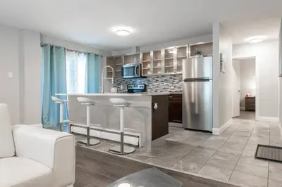 a kitchen with a stainless steel refrigerator and a counter at ENTIRE 2 BEDROOM APARTMENT UPTOWN WATERLOO - e2 in Waterloo